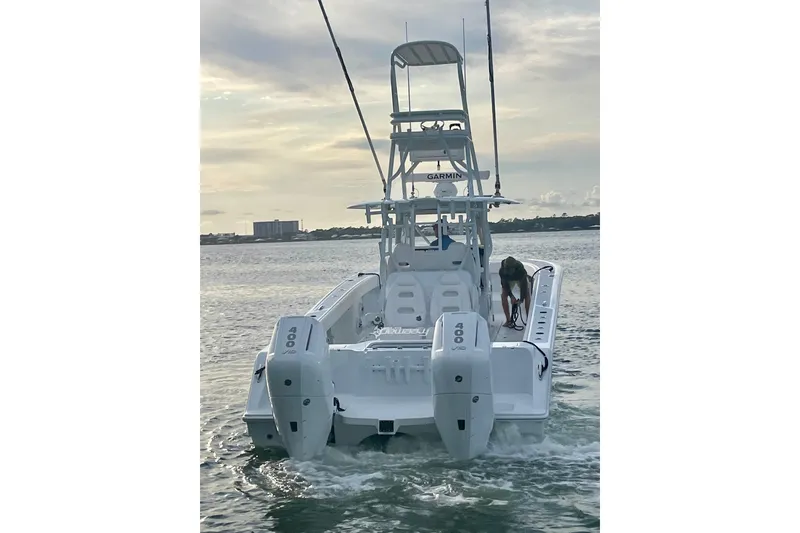 Slide: The Image of 2023 Freeman 34VH boat with dual 400 engines on calm water at sunset. - 2