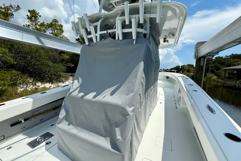Slide: The Image of 2023 Freeman 34VH boat with covered console, docked near lush greenery. - 3