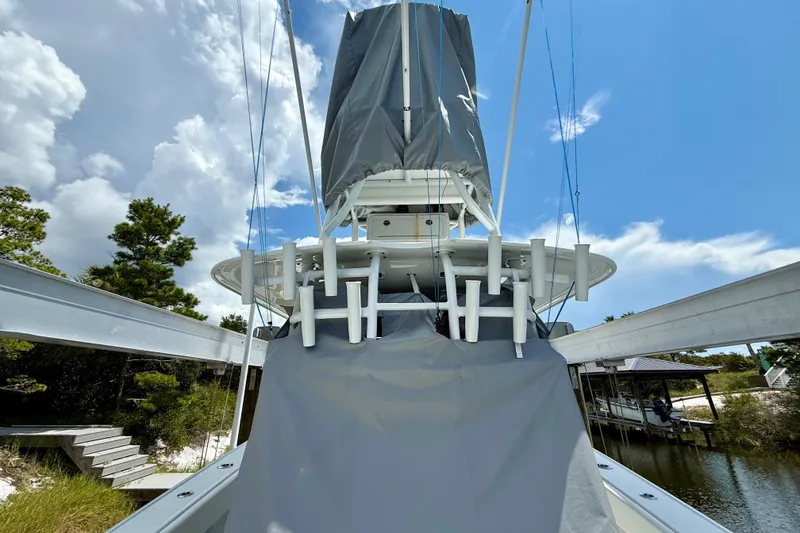 Slide: The Image of 2023 Freeman 34VH boat with covered equipment, docked near trees under a blue sky. - 4