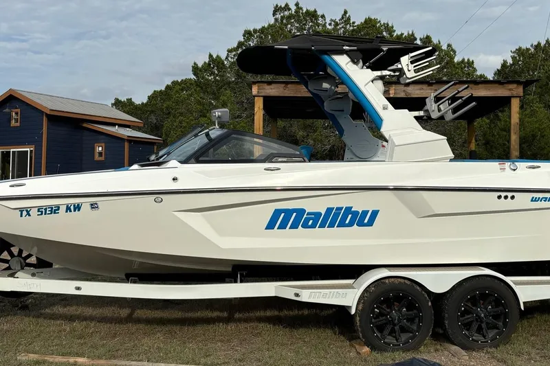 The Image of 2022 Malibu Wakesetter 23 MXZ boat on trailer, parked outdoors. - 1