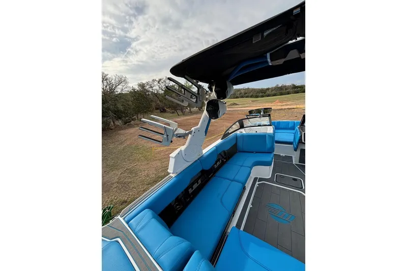 Slide: The Image of 2022 Malibu Wakesetter 23 MXZ interior with blue seating and wakeboard rack. - 13