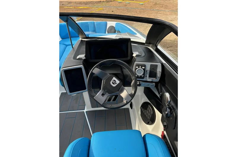 Slide: The Image of 2022 Malibu Wakesetter 23 MXZ boat interior with blue seating and modern dashboard. - 15