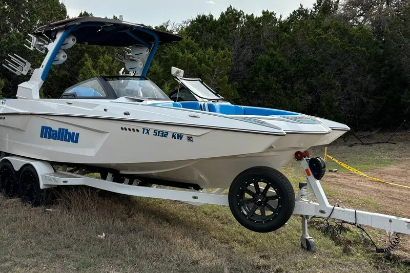 Slide: The Image of 2022 Malibu Wakesetter 23 MXZ boat on trailer, parked on grass. - 5