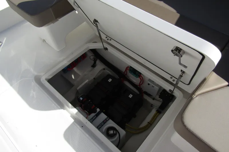 Slide: The Image of Open storage compartment in 2025 Nimbus Tender 9 boat, revealing battery and wiring. - 41