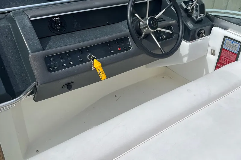 Slide: The Image of 1991 Sea Ray 270 Sundancer boat dashboard with steering wheel and control panel. - 15