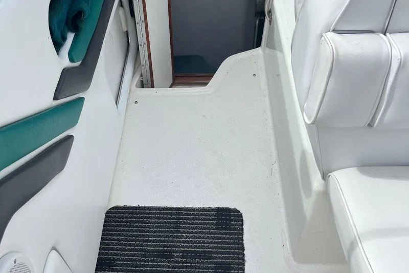 Slide: The Image of Interior view of 1991 Sea Ray 270 Sundancer boat with white seating and striped mat. - 16