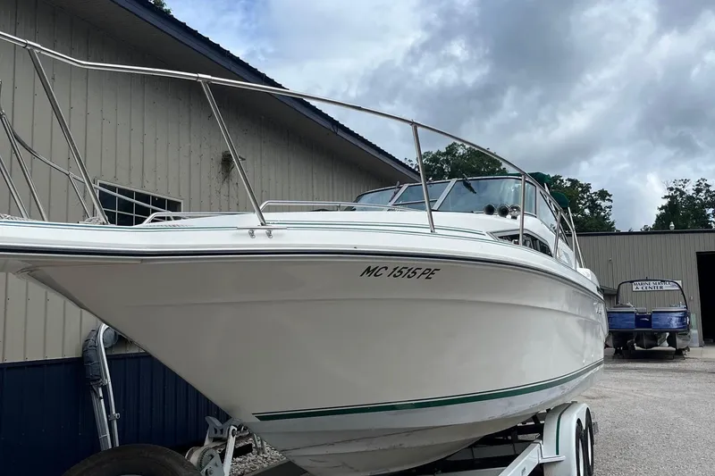 Slide: The Image of 1991 Sea Ray 270 Sundancer boat on trailer, parked near a marine service center. - 23
