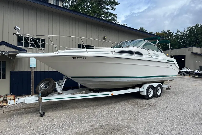 Slide: The Image of 1991 Sea Ray 270 Sundancer boat on trailer, parked outside a building. - 24