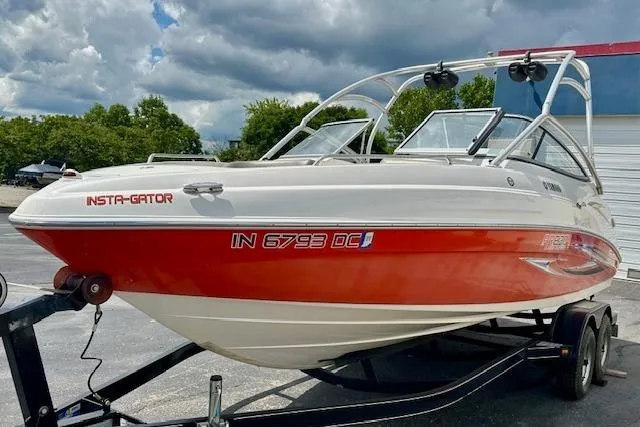 Slide: The Image of 2007 Yamaha AR 230 boat on trailer, red and white, parked outdoors. - 2