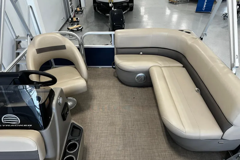 Slide: The Image of 2023 Sun Tracker Bass Buggy 16 XL Select interior with beige seating and steering console. - 4