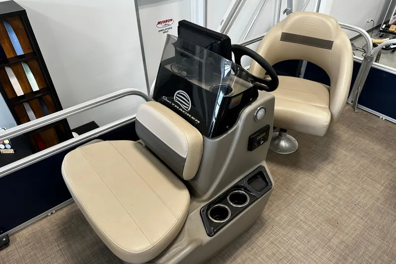 Slide: The Image of 2023 Sun Tracker Bass Buggy 16 XL Select interior with beige seating and steering console. - 8