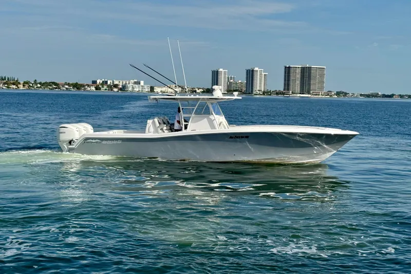 The Image of 2024 Invincible 39 Open Fisherman boat cruising on calm waters near city skyline. - 0