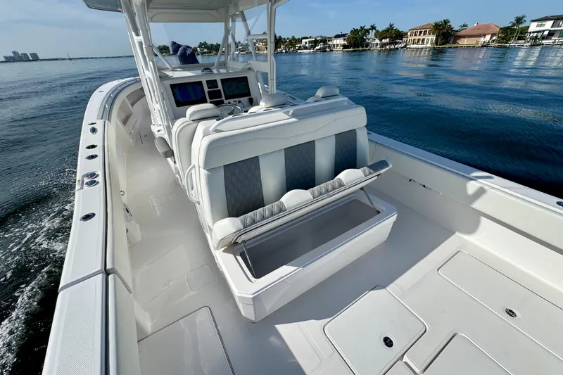 Slide: The Image of 2024 Invincible 39 Open Fisherman boat interior with seating and console on calm water. - 15