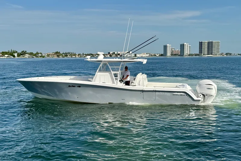 Slide: The Image of 2024 Invincible 39 Open Fisherman boat cruising on calm waters near city skyline. - 23