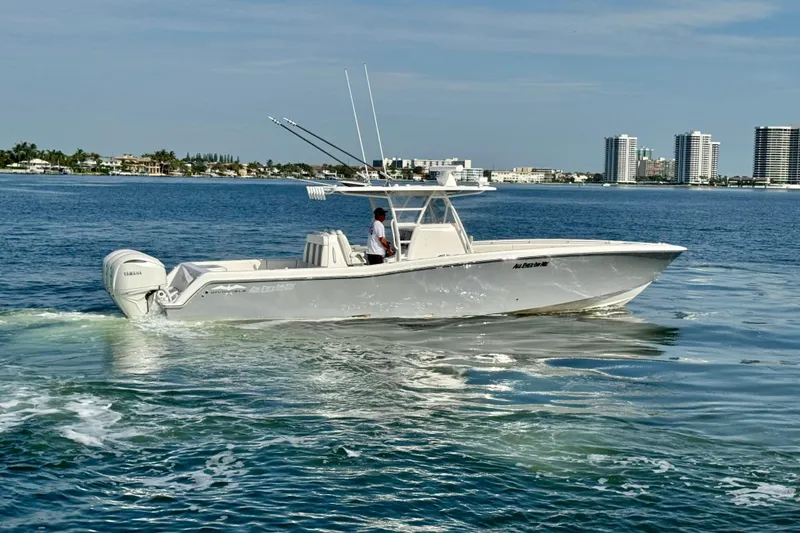 Slide: The Image of 2024 Invincible 39 Open Fisherman boat cruising on calm waters near city skyline. - 26