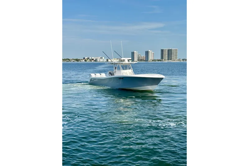 Slide: The Image of 2024 Invincible 39 Open Fisherman boat cruising on calm waters near city skyline. - 27