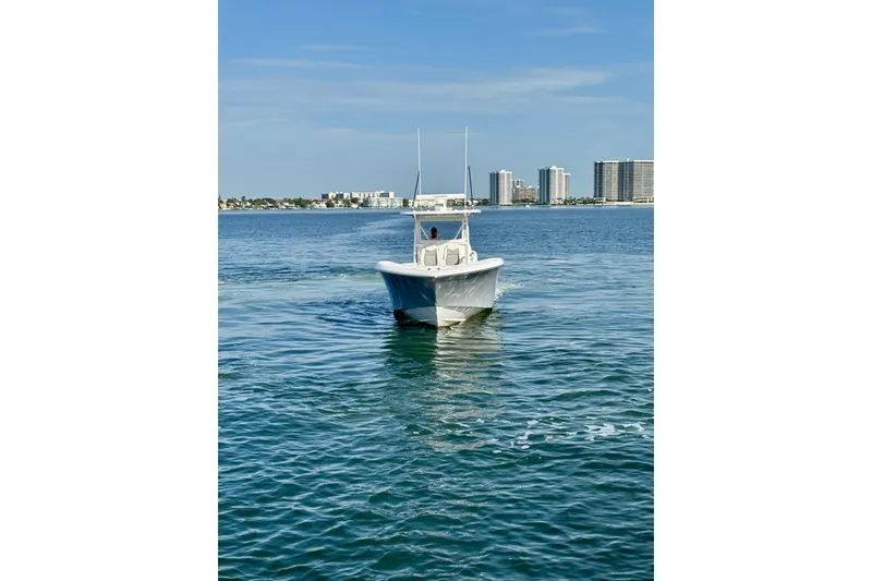 Slide: The Image of 2024 Invincible 39 Open Fisherman boat on calm water with city skyline. - 28