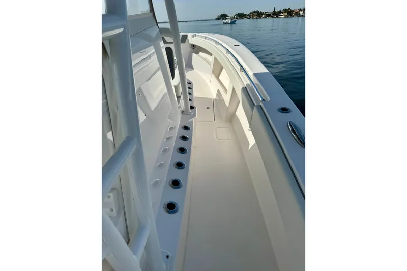 Slide: The Image of 2024 Invincible 39 Open Fisherman boat deck with rod holders, on calm water. - 8