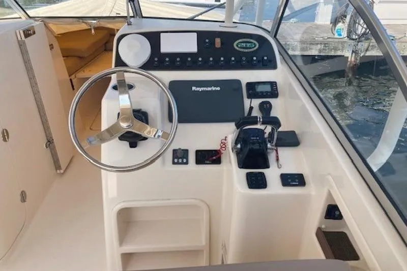 Slide: The Image of 2014 Grady-White Freedom 285 boat helm with steering wheel and navigation controls. - 10