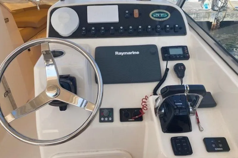 Slide: The Image of 2014 Grady-White Freedom 285 boat dashboard with steering wheel and Raymarine electronics. - 4
