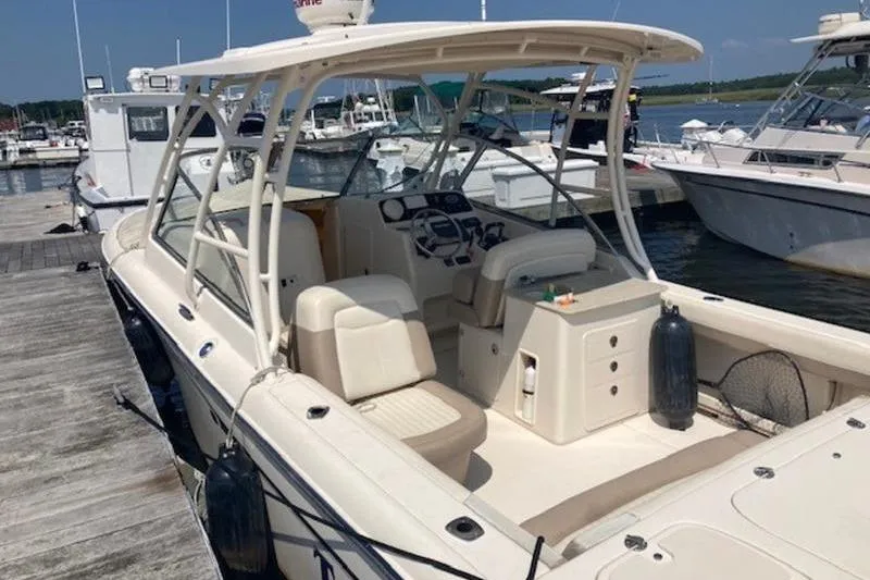 Slide: The Image of 2014 Grady-White Freedom 285 boat docked at marina, featuring spacious seating and helm. - 6