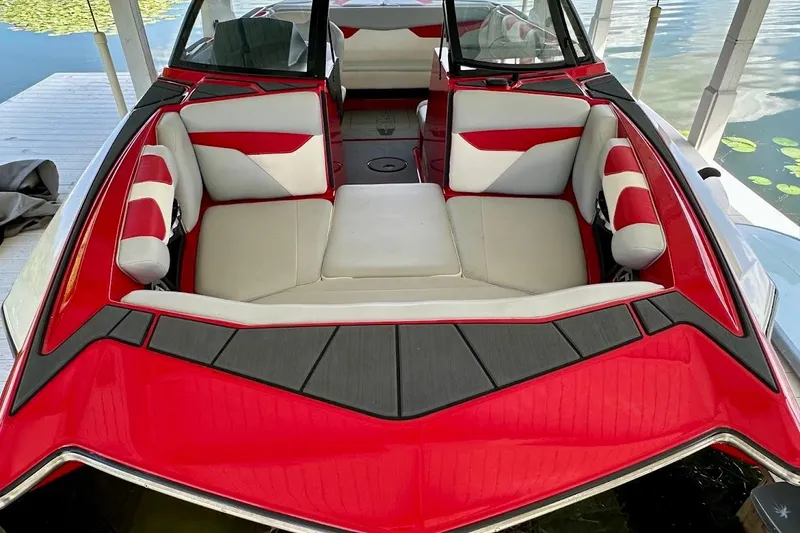 Slide: The Image of 2021 Axis A20 boat interior with red and white seating, docked by the water. - 45