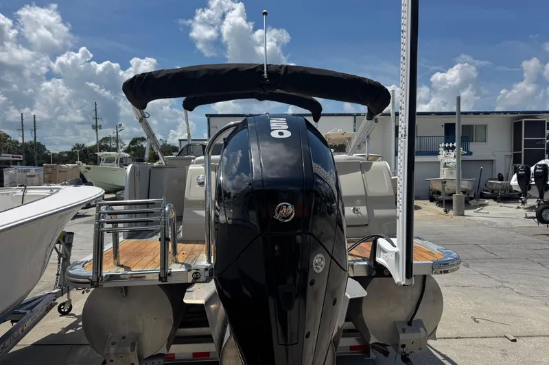 Slide: The Image of 2019 Avalon Catalina Platinum Elite boat with powerful outboard motor, docked under clear skies. - 12