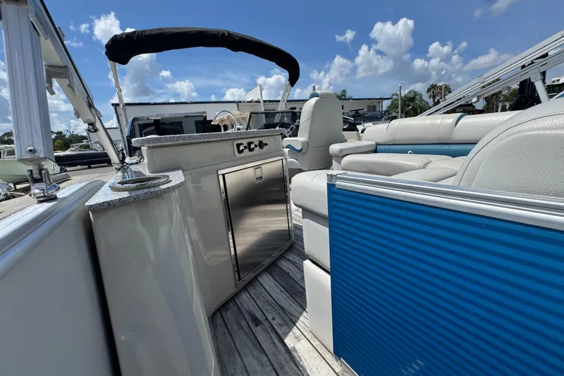 Slide: The Image of 2019 Avalon Catalina Platinum Elite boat interior with seating and helm, under a clear sky. - 34