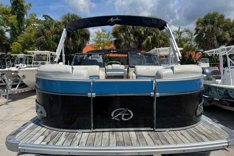 Slide: The Image of 2019 Avalon Catalina Platinum Elite Windshield 25' pontoon boat, docked with lush greenery background. - 6