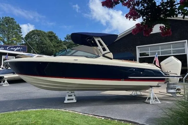 The Image of 2026 Chris-Craft Sportster 28 boat displayed outdoors with blue and cream design. - 0