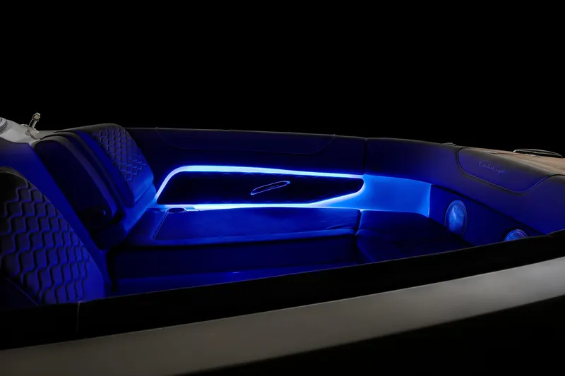 Slide: The Image of 2025 Chris-Craft Sportster 28 interior with blue LED lighting and luxurious seating. - 25