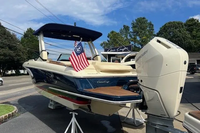 Slide: The Image of 2026 Chris-Craft Sportster 28 boat with American flag, displayed outdoors. - 3