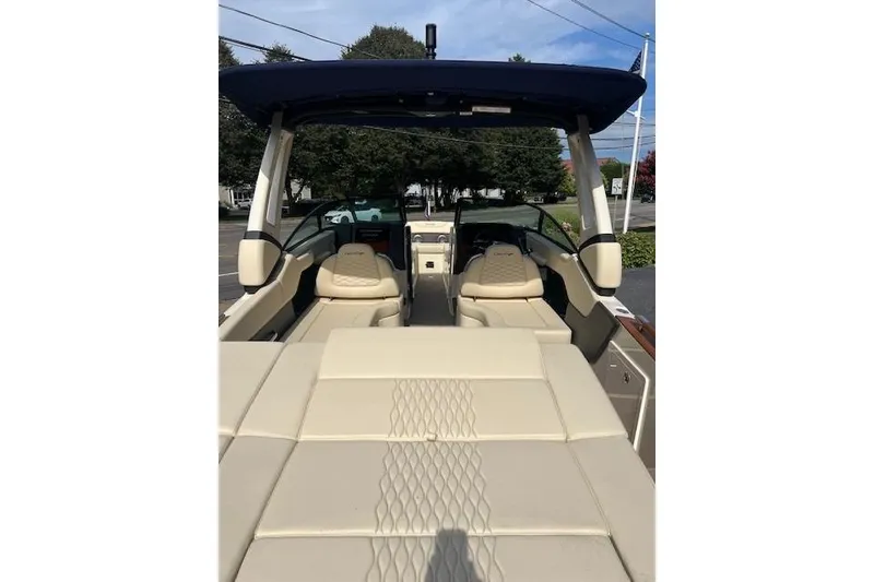 Slide: The Image of 2026 Chris-Craft Sportster 28 boat interior with beige seating and blue canopy. - 9