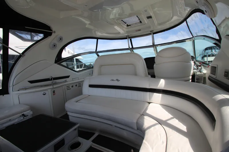 Slide: The Image of 2008 Sea Ray 44 Sundancer interior with luxurious white seating and panoramic windows. - 13