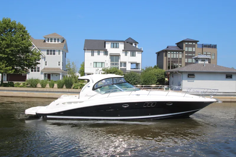 Slide: The Image of 2008 Sea Ray 44 Sundancer yacht cruising near waterfront homes. - 3