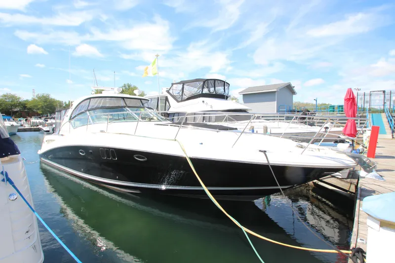 Slide: The Image of 2008 Sea Ray 44 Sundancer yacht docked at marina under clear blue sky. - 4