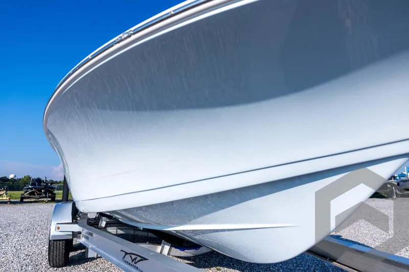 Slide: The Image of 2026 Tidewater 2110 Bay Max boat on trailer, close-up view, clear blue sky. - 12