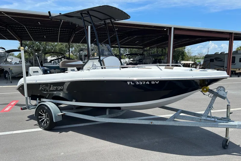 The Image of 2020 Key Largo 1800 CC boat on trailer, parked outdoors under a clear sky. - 1
