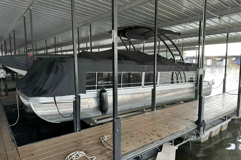 Slide: The Image of 2018 Landau Atlantis 250 Cruise pontoon boat docked under a covered marina. - 20