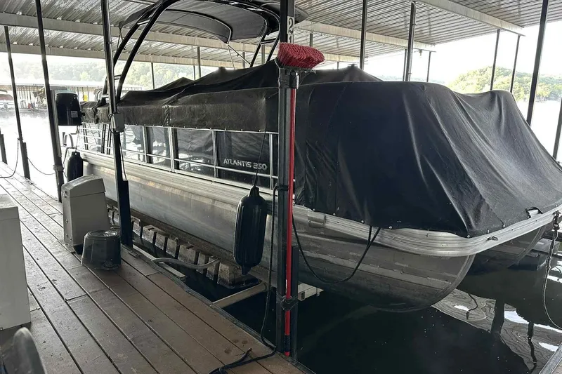 Slide: The Image of 2018 Landau Atlantis 250 Cruise pontoon boat docked with cover in marina. - 25