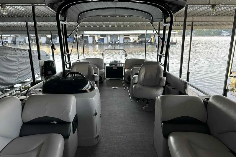 Slide: The Image of 2018 Landau Atlantis 250 Cruise pontoon boat interior at dock, featuring comfortable seating. - 3