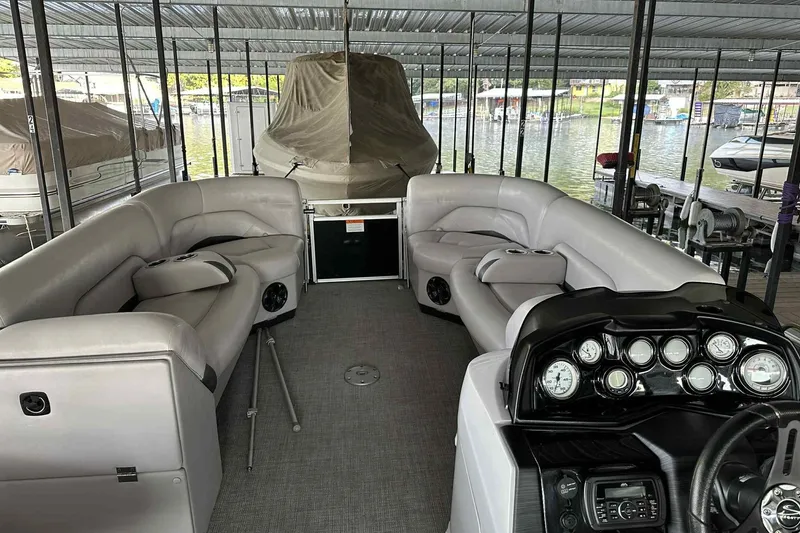 Slide: The Image of 2018 Landau Atlantis 250 Cruise pontoon boat interior with plush seating and control panel. - 5