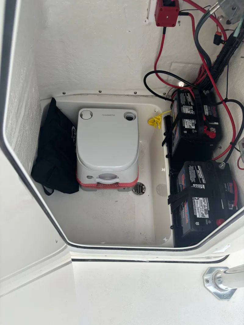 Slide: The Image of Storage compartment in a 2026 Key West 203 FS boat with batteries and portable toilet. - 16