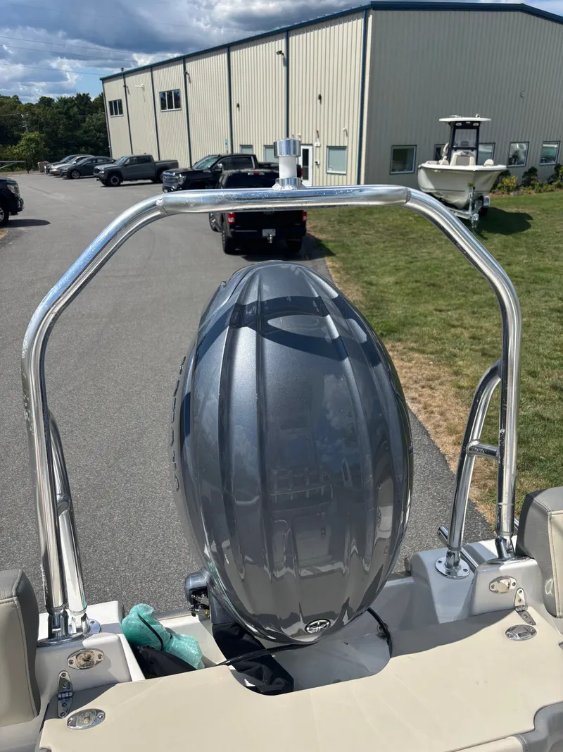 Slide: The Image of 2026 Key West 203 FS boat with a sleek outboard motor, parked near a building. - 26