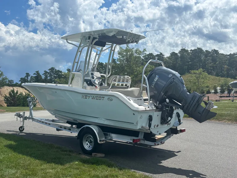 Slide: The Image of 2026 Key West 203 FS boat on trailer, parked outdoors under a cloudy sky. - 4