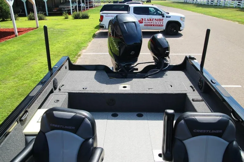 Slide: The Image of 2022 Crestliner 2100 Raptor boat interior with motor, parked near a marina. - 10