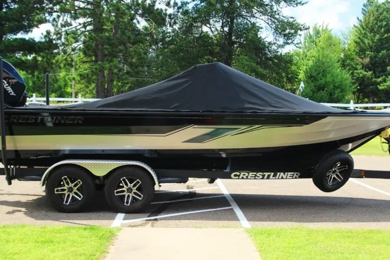 Slide: The Image of 2022 Crestliner 2100 Raptor boat on trailer, covered, parked outdoors. - 14