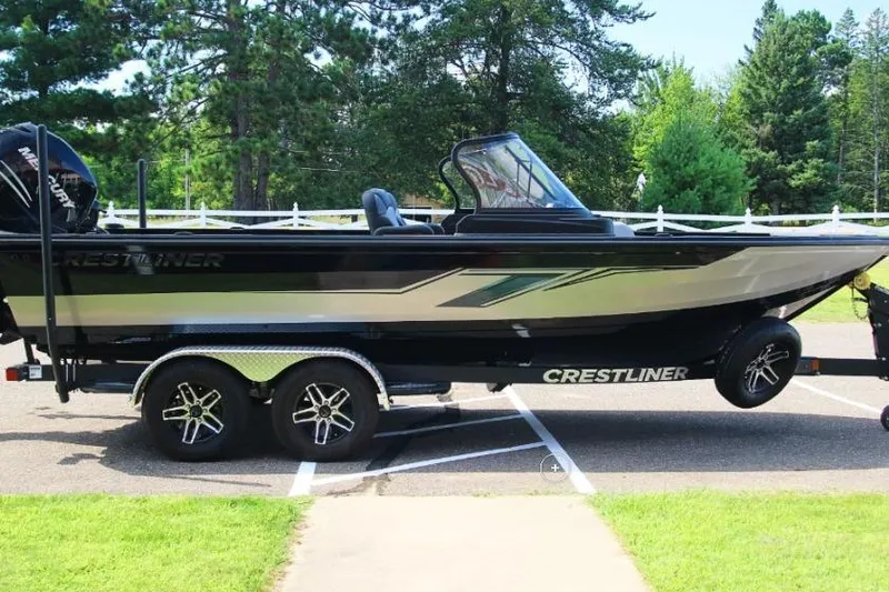 Slide: The Image of 2022 Crestliner 2100 Raptor boat on trailer, parked outdoors with trees in background. - 3