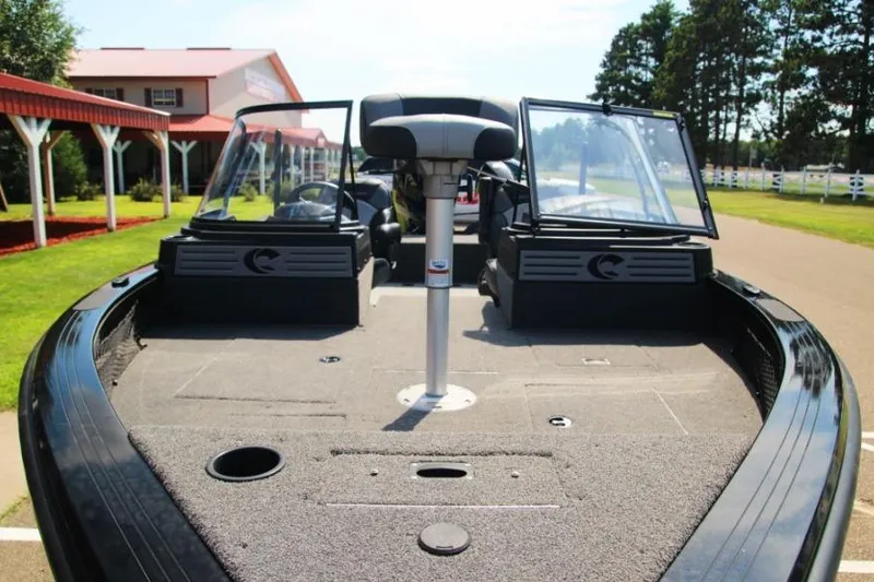 Slide: The Image of 2022 Crestliner 2100 Raptor boat with open deck and seating, parked outdoors. - 4