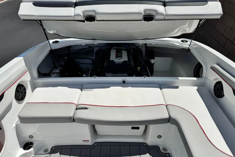 Slide: The Image of 2021 Tahoe T700 boat interior with open engine compartment, white seating, and red trim. - 17